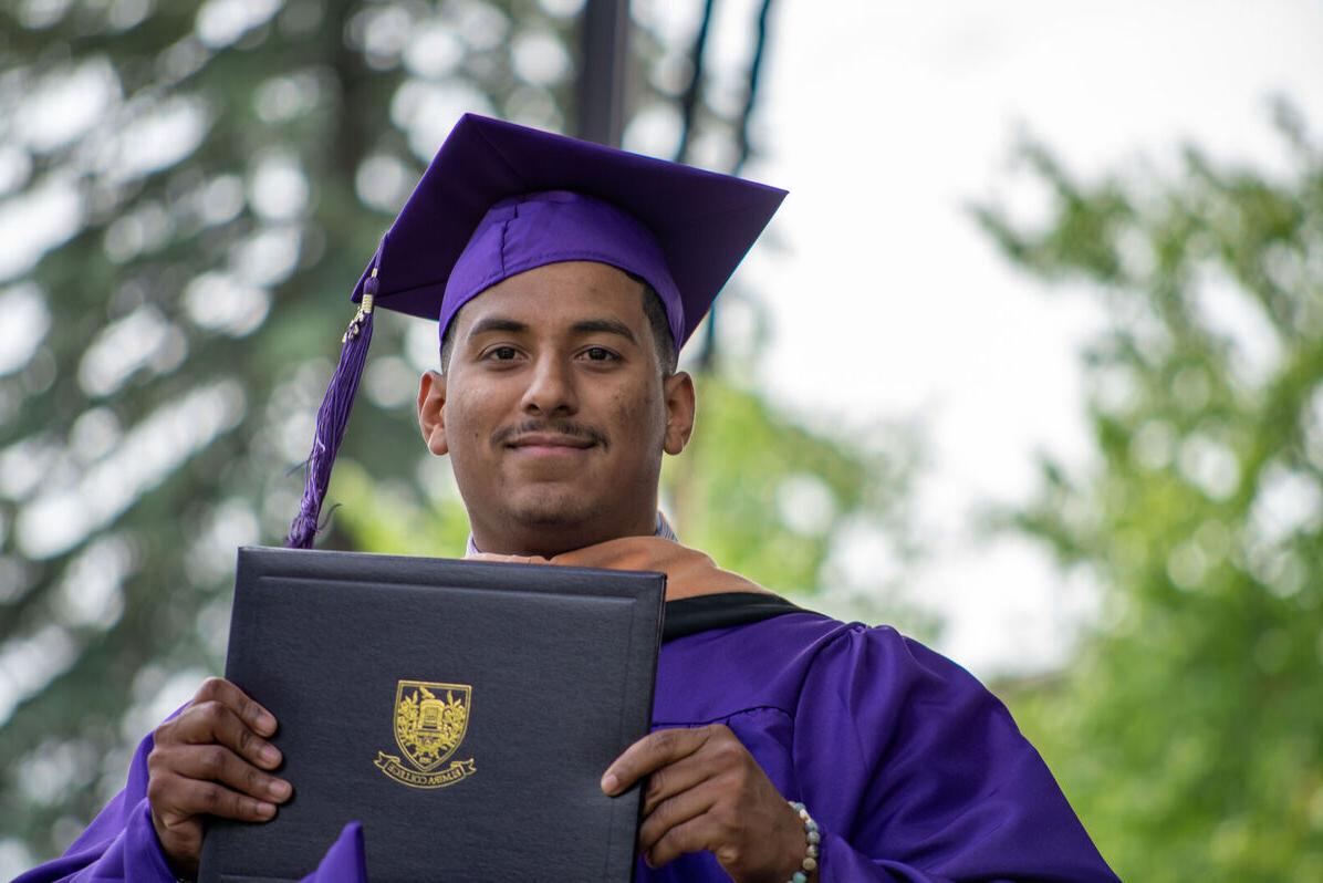 A male graduate shows off his degree during 毕业典礼